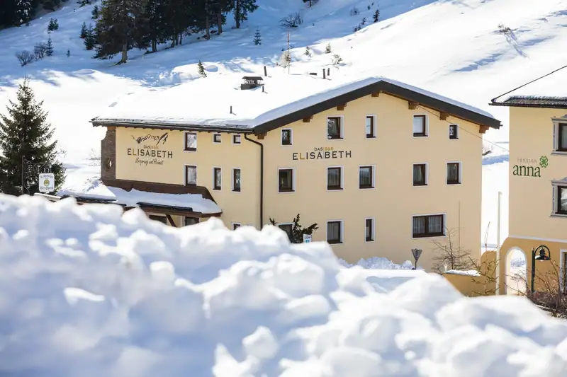 Das B&B Elisabeth hinter einem Schneehaufen an einem sonnigen Wintertag