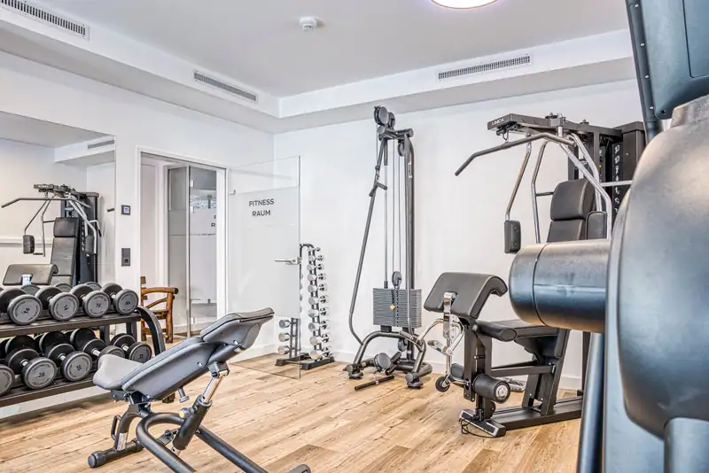 Gym with glass door, dumbbells, weight bench and strength equipment