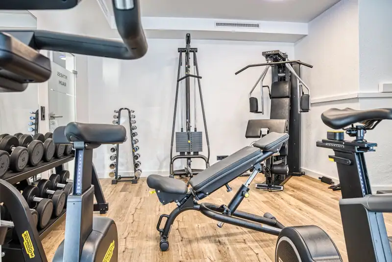 Adjustable weight bench in front of strength station and cable pulley