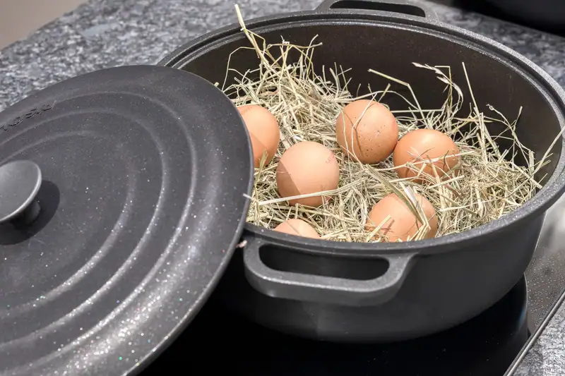 Fresh eggs in hay in a black pot