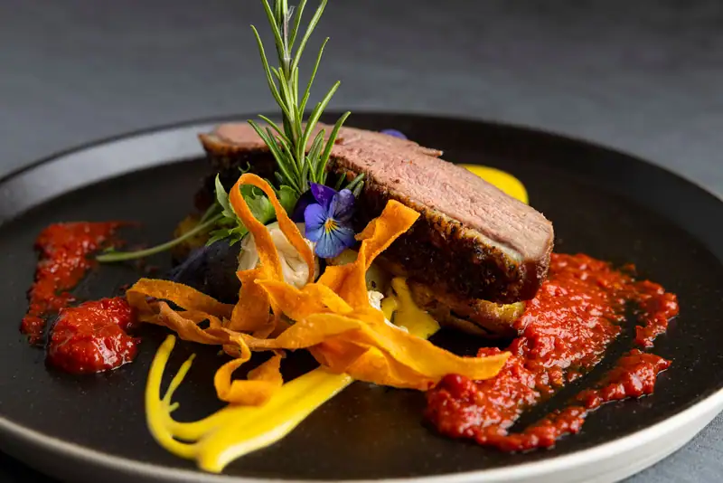 Rosa gebratene Entenbrust mit Karottenchips und Paprikasauce