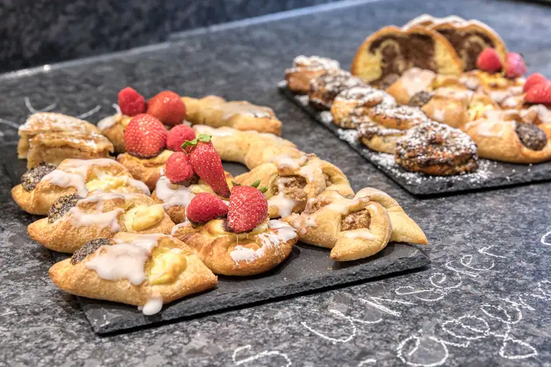 Sweet pastries with strawberries and raspberries, marble cake behind