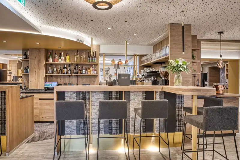 The GoldBar with wooden counter, bar stools and bottle shelves