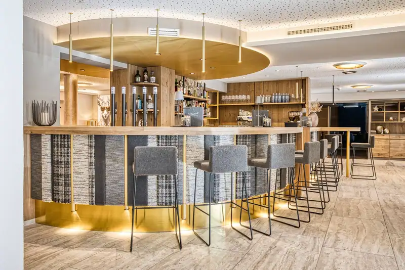The GoldBar with round counter, woven panelling, golden ceiling disc and grey bar stools