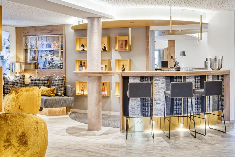 The GoldBar with wood, golden wall shelves and bar stools