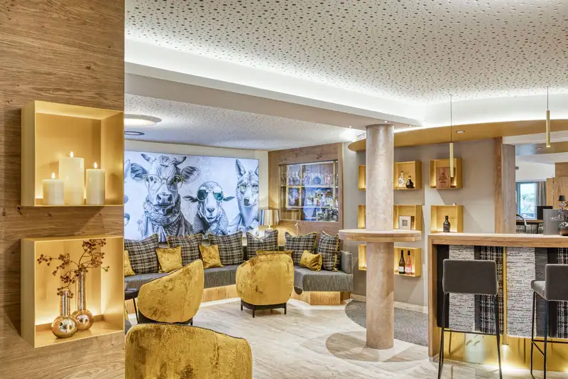Lounge with golden armchairs and a large mural of animals wearing sunglasses