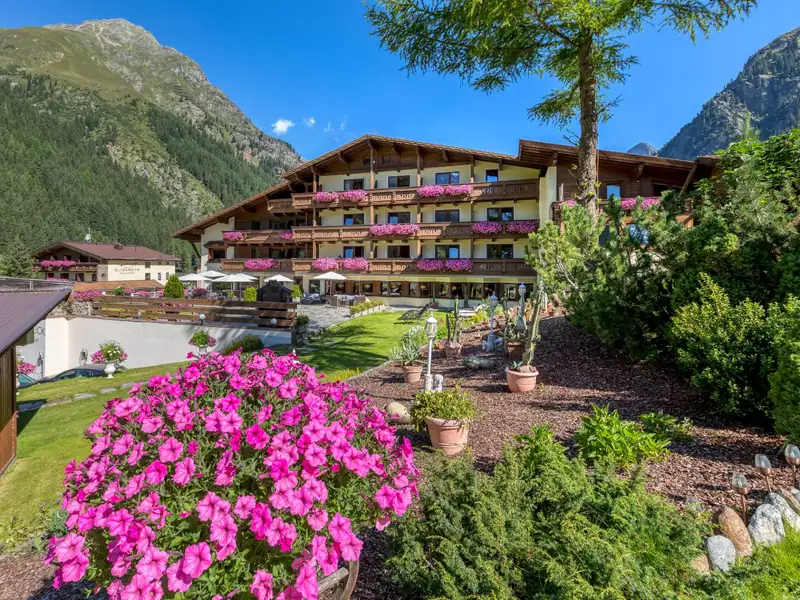 Hotel garden with flowers in front of GenussHotel Sonnblick in summer
