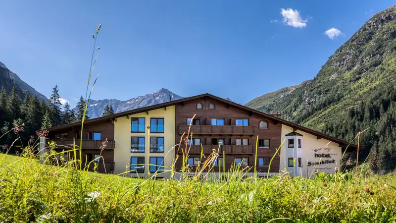 GenussHotel Sonnblick behind a flowering mountain meadow in the Pitztal