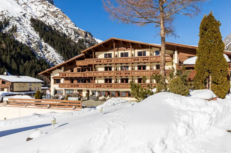 Hotelfassade mit Holzbalkonen im Schnee