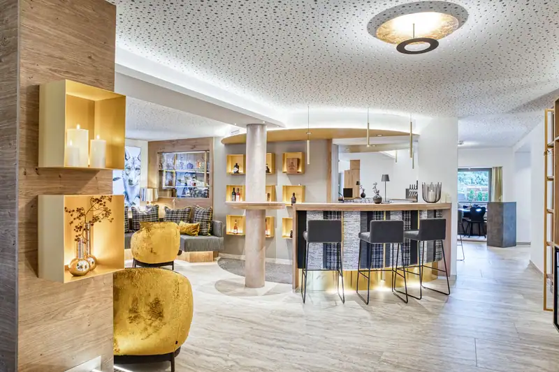 Lounge with bar, golden armchairs and illuminated wall niches