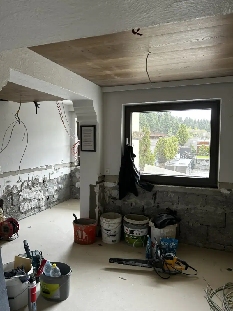Baustelle mit neuem Fenster, Holzdecke, Farbeimern und Werkzeug