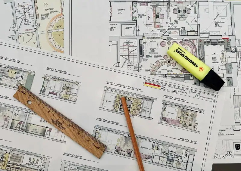 Ausgedruckte Grundrisse und Ansichten von Rezeption, Hotelhalle und Buffet mit Lineal, Bleistift und Textmarker