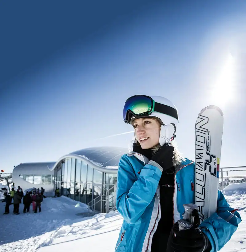 Skifahrerin mit Ski vor der Bergstation am Gletscher