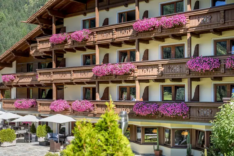 Wooden balconies with lush pink petunias on the hotel facade