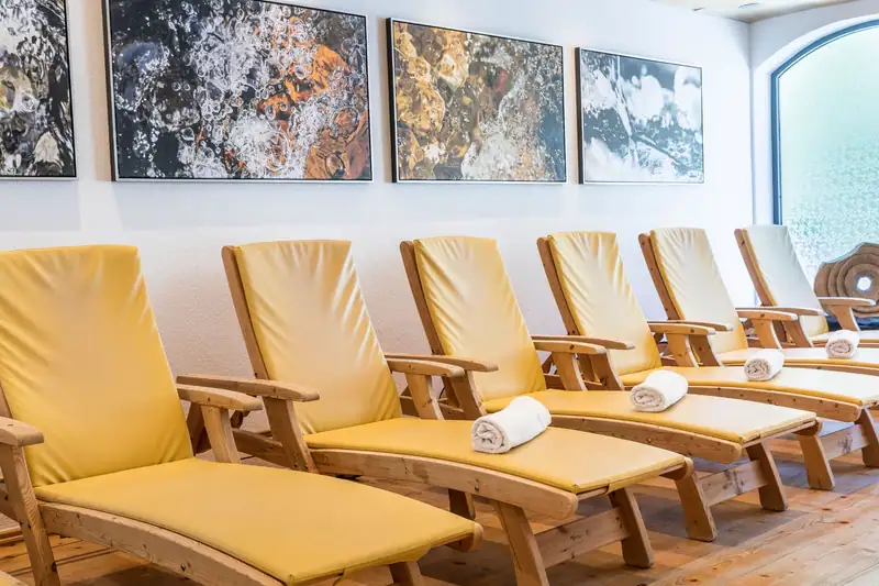 Row of yellow loungers with rolled towels beneath water pictures
