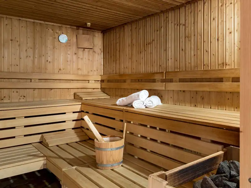 Inside the Finnish sauna with wooden benches and sauna stove