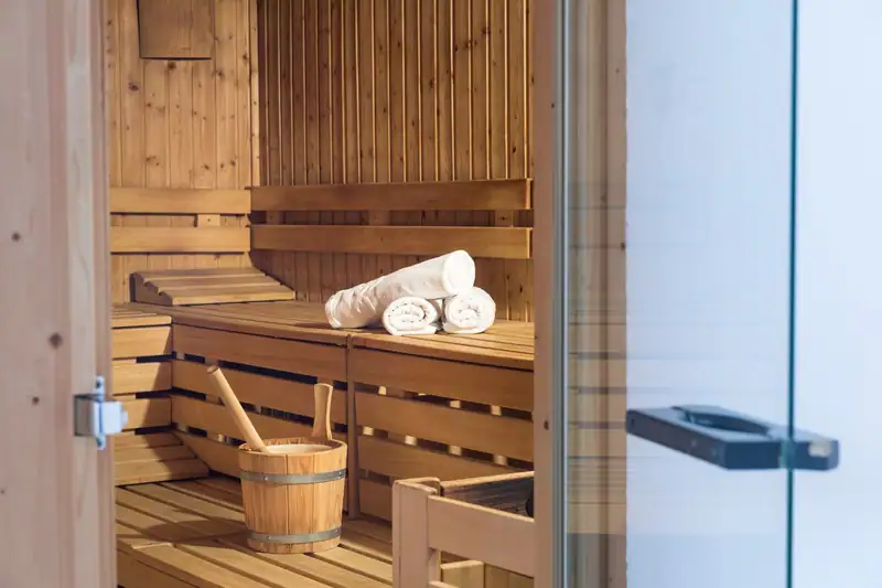 Finnish sauna with infusion bucket and towels, view through the glass door