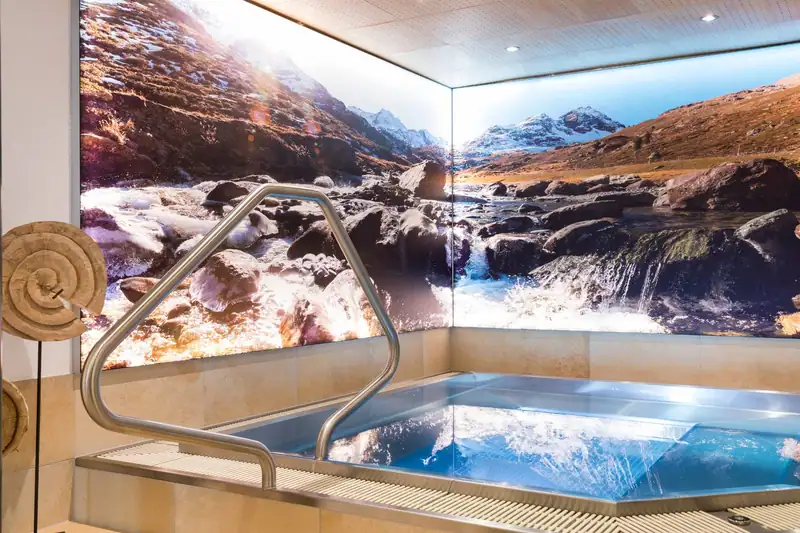 Whirlpool in front of a mural with a mountain stream