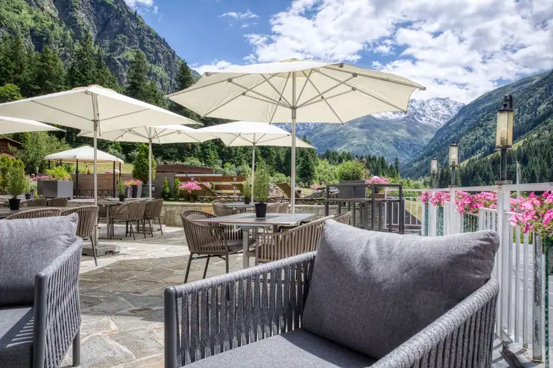 Sun terrace with umbrellas and a view of the valley in summer