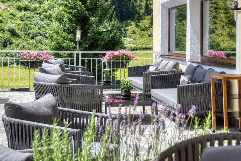 Lounge furniture on the summer terrace with flowers and lavender