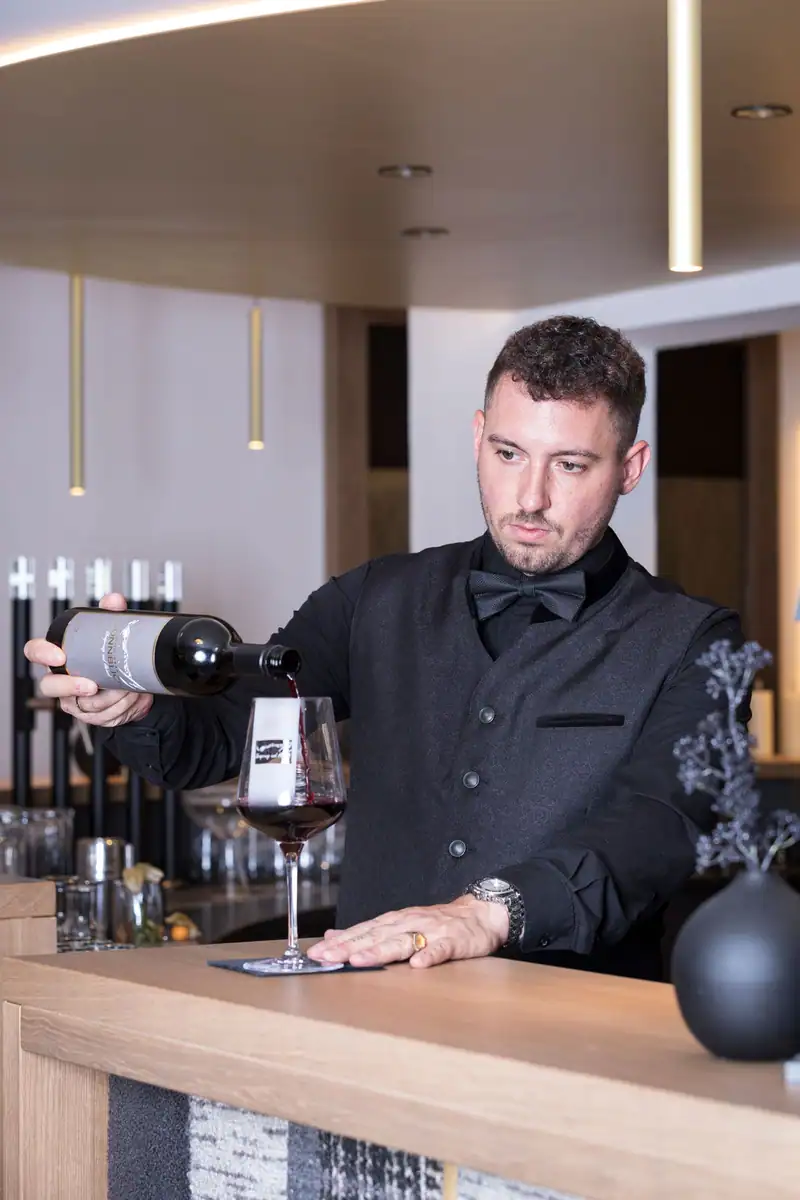 Waiter pouring red wine from the wine cellar