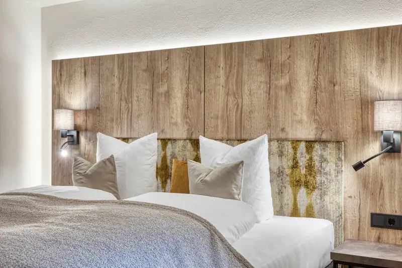 Double bed with wooden wall and indirect lighting