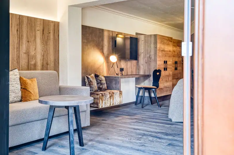 Living area with pull-out sofa bed, side table, bench seat and desk