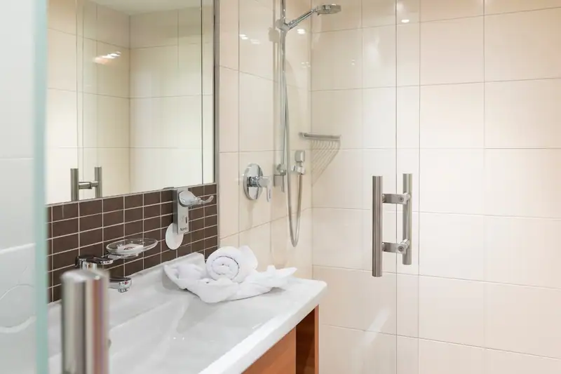 Shower with glass door next to the washbasin